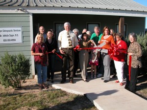 Judge Marvin Quinney, Dr. JoNelle Zager, and Floresville Chamber of Commerce directors and members cutting the Grand Opening ribbon.
